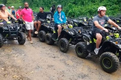 Group riding ATVs on a dirt trail in Roatan, Honduras.